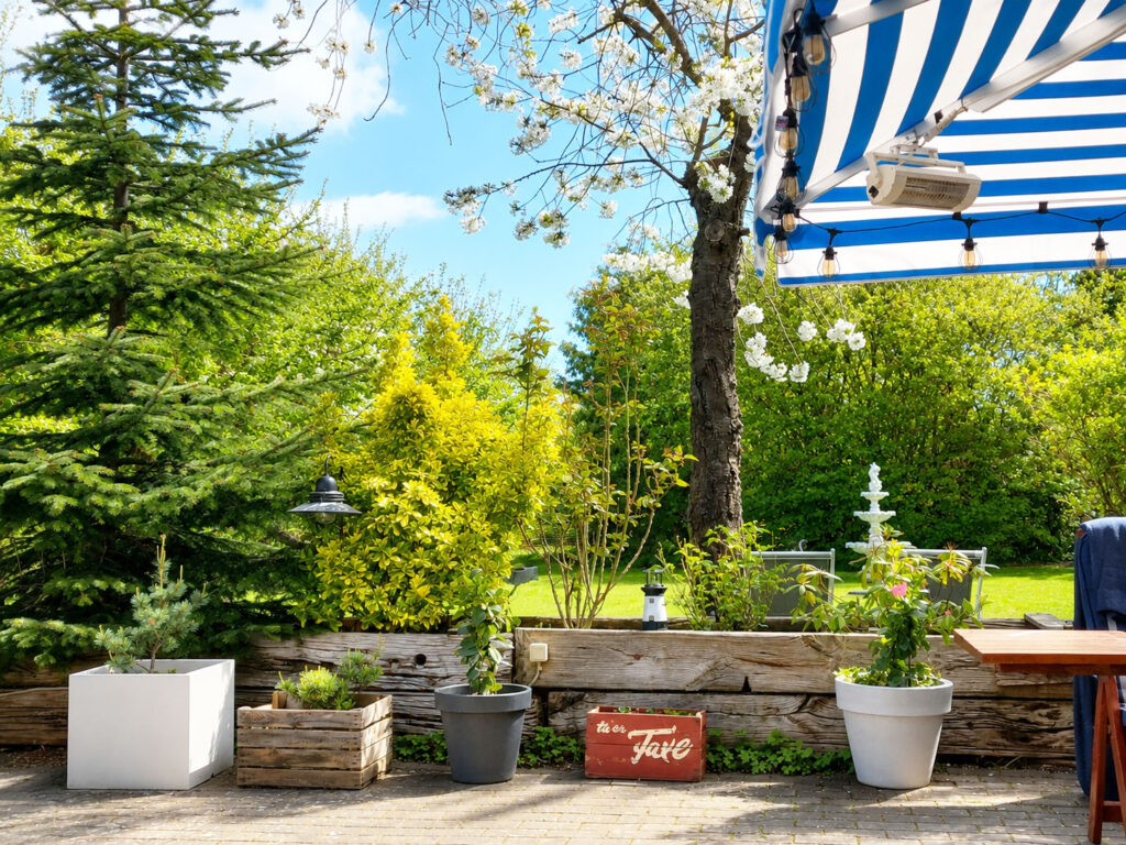 Sunny view from the private terrace overlooking the secluded landscaped garden with mature greenery, apple trees and plum trees